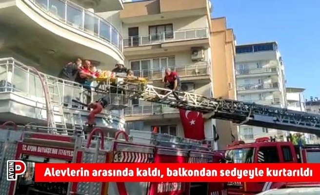 Alevlerin arasında kaldı, balkondan sedyeyle kurtarıldı