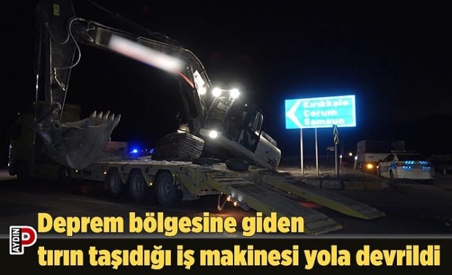Deprem bölgesine giden tırın taşıdığı iş makinesi yola devrildi